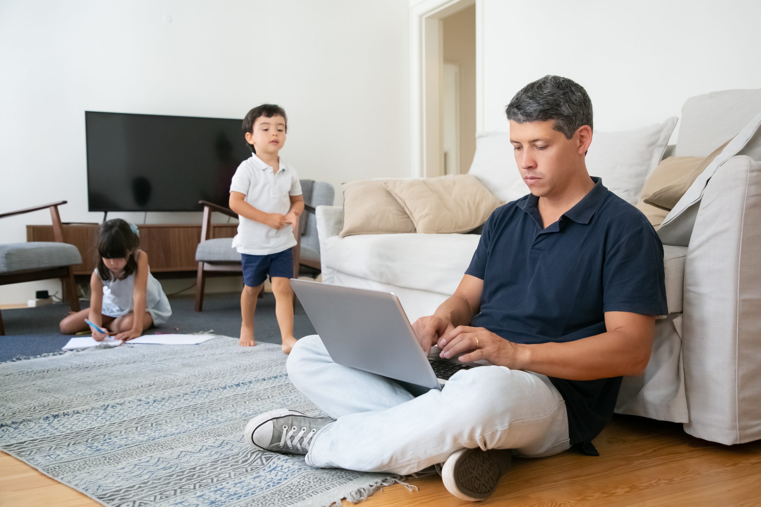 Focused dad sitting on floor and using pc